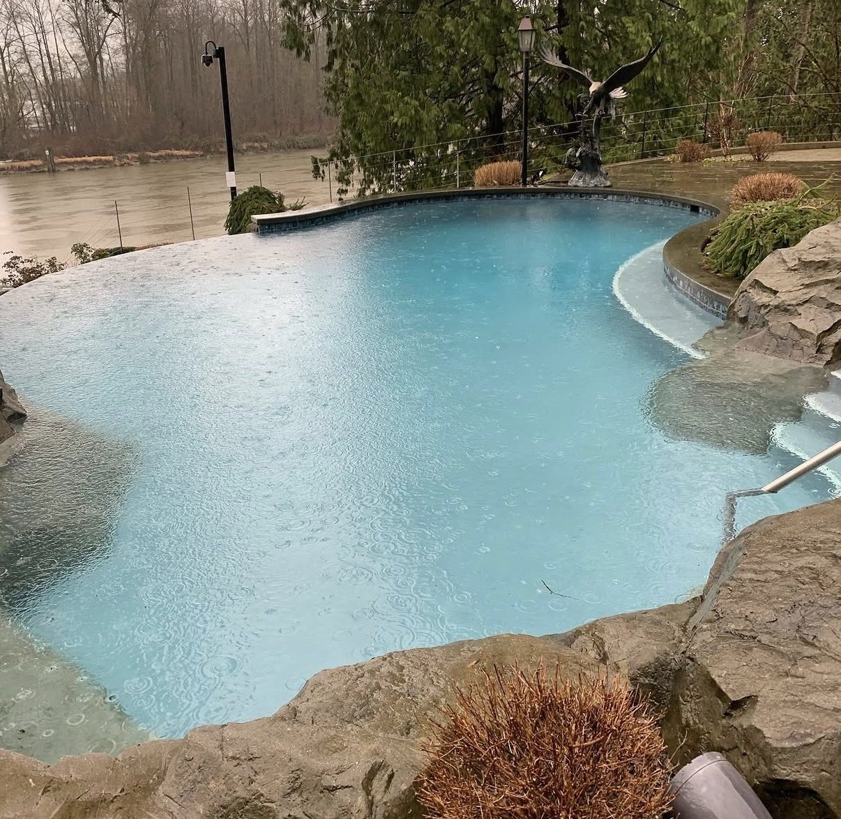 Infinity edge pool with natural rockwork overlooking the Fraser River