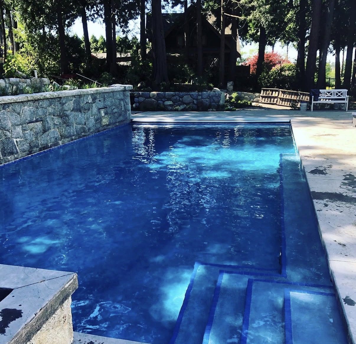 Deep blue pool beside a granite stone wall in South Surrey
