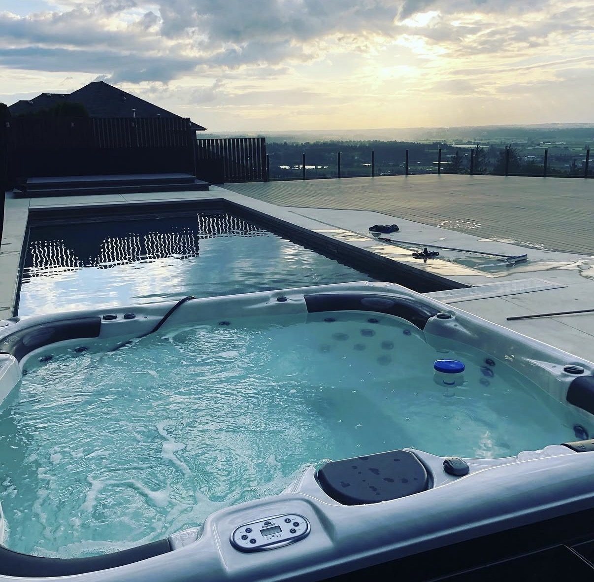 Hot tub and lap pool at sunset overlooking the Fraser Valley, maintained by JK Pools and Spas